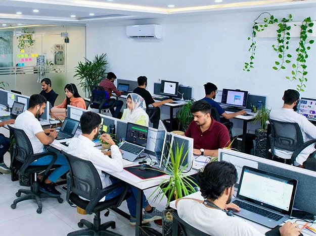 A team of custom software developers working in the Budget Trips LTDoffice building in Lahore, Pakistan. The developers are working on a custom software development project, using various tools and technologies to create a high-quality software solution. The image is relevant to the keywords "about us," "custom software development company office," "web development company," "mobile app development company," "application development company," "IT consulting agency" "IT services company," "IT solutions company," "IT outsourcing company," "quality assurance," "mobile apps," "data analytics," "artificial intelligence," "machine learning," "MVP builder," "dedicated teams," "history of Budget Trips LTDmission," and "Budget Trips LTDoffice building."